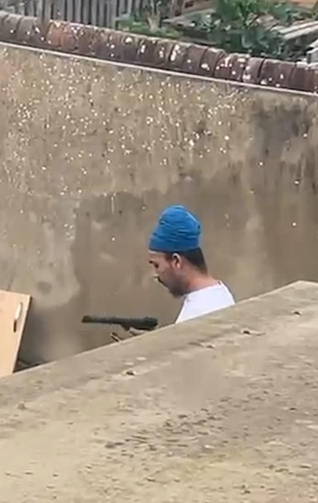 Moment 'weapons-obsessed' Vickrum Digwa brandishes gun in his back garden three years before he murdered Henry Nowak